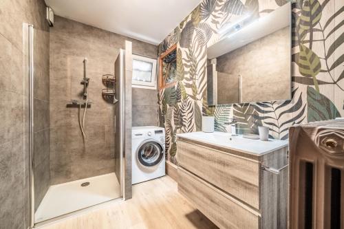 a bathroom with a washing machine and a washer at Gîte Du Noiret in Cruseilles