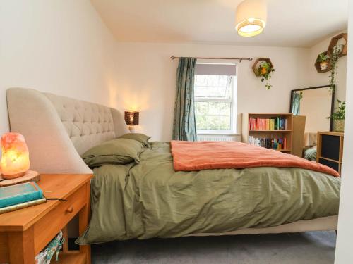 a bedroom with a bed and a desk and a window at Manning's View in Barnstaple