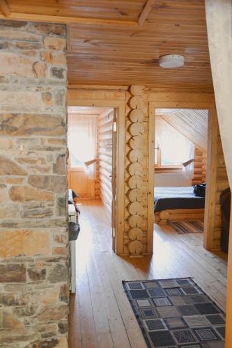 a living room with a stone wall and a bedroom at Будиночок улюблений in Shirokoye