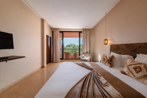 a bedroom with a large bed and a balcony at Al Maaden Villa Hotel & Spa in Marrakesh