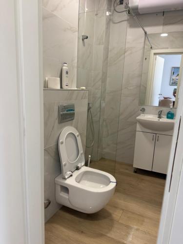 a white bathroom with a toilet and a sink at Sunshine view in Seoca