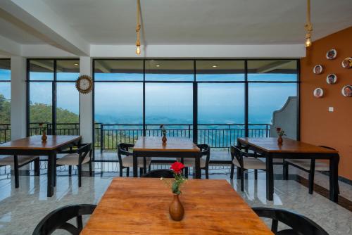a restaurant with tables and chairs and large windows at leisure Mount View in Haputale