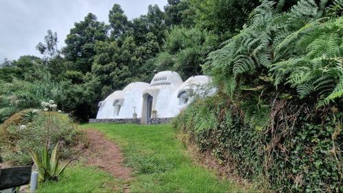 a large white domed building in a garden at Arambha ecovillage farmstay in Tábua
