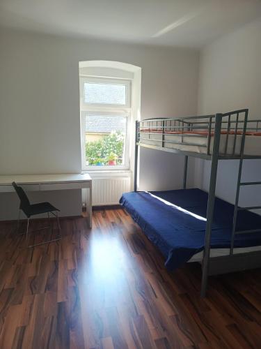 a bedroom with a bunk bed and a desk at Spacious Heritage Apartment for Groups in Bruck an der Leitha