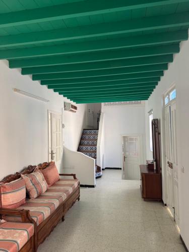 a living room with a couch and a green ceiling at Authentic, quiet and spacious house in El Guecheïne