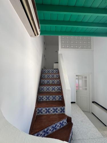 a hallway with stairs with a green ceiling at Authentic, quiet and spacious house in El Guecheïne