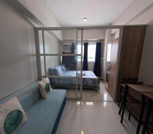 a bedroom with a bed and a couch in a room at Mactan Airport 1BR Resort with Pool in Mactan Island