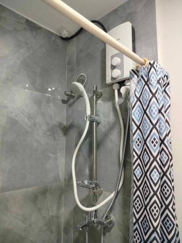 a shower in a bathroom with a shower head at Mactan Airport 1BR Resort with Pool in Mactan Island