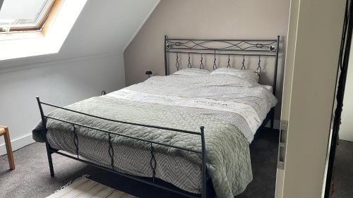 a bedroom with a bed with a metal frame at Homestay Bij de Heldinnen in Helden