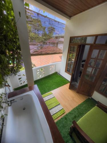 a bathroom with a tub and a yard with green grass at Lava Ella in Ella