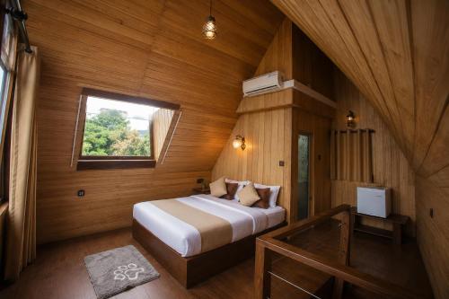 a bedroom with a bed in a wooden room at Lava Ella in Ella