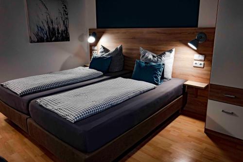 a bedroom with two beds with blue and white pillows at Stadtplatz23 B&B in Bogen