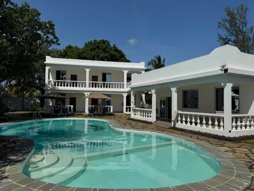 a large swimming pool in front of a house at M&H Boutique Hotel in Mombasa