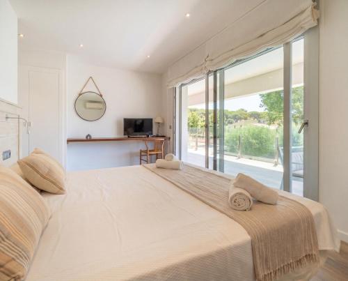a bedroom with a large bed with a large window at Modern Villa Olivera with Private Pool in Calella de Palafrugell
