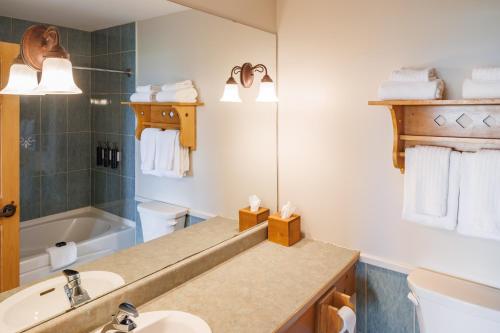 a bathroom with a sink and a mirror and a tub at Rodd Crowbush Golf & Beach Resort in Morell