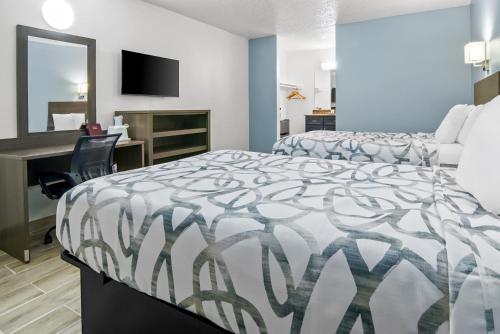 a hotel room with two beds and a desk at Americas Best Value Inn Weatherford in Weatherford