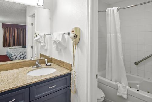 a bathroom with a shower and a blow dryer at Americas Best Value Inn Weatherford in Weatherford