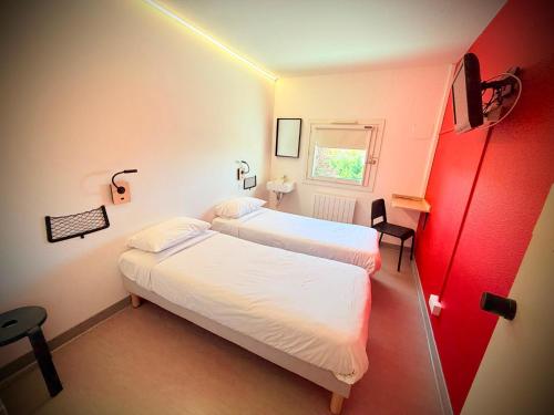 a hotel room with two beds and a window at Unisotel Montauban EX F1 in Montauban