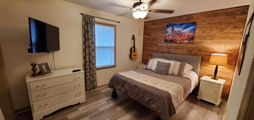 a bedroom with a bed and a flat screen tv at Charming Country Cottage in Murfreesboro