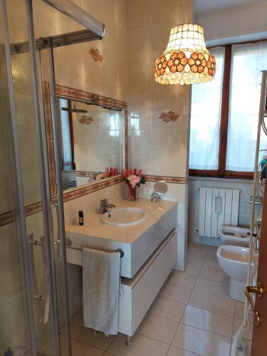 ein Badezimmer mit Waschbecken, Toilette und Kronleuchter in der Unterkunft Fronte Mare in Quercianella