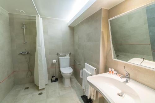 a bathroom with a toilet and a sink and a mirror at Hotel Eurosol Leiria & Jardim in Leiria