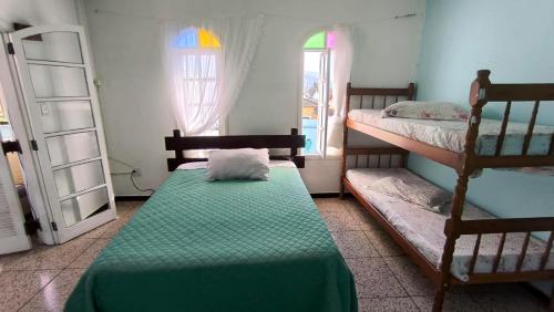 a bedroom with two bunk beds and a window at Pousada Pontal de Santa Marina - Caraguatatuba in Caraguatatuba