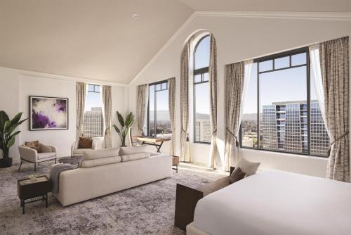 a bedroom with a bed and a living room with windows at Signia by Hilton San Jose in San Jose