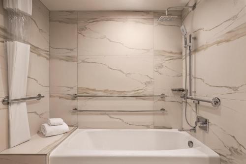 a white bath tub in a bathroom with marble walls at Signia by Hilton San Jose in San Jose