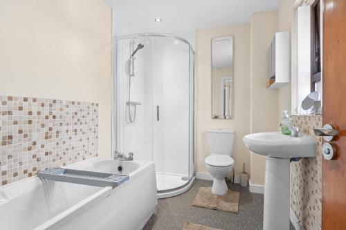 a bathroom with a tub and a toilet and a sink at The Nest in Belfast