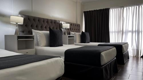 a hotel room with two beds and a large window at Ker Recoleta Hotel in Buenos Aires