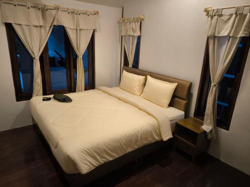 a bedroom with a bed with a cat sitting on it at Bakesense home 01 in Ko Phangan