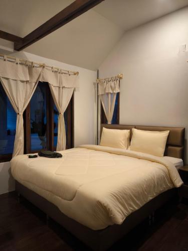 a bedroom with a large bed with white sheets and a window at Bakesense home 01 in Ko Phangan