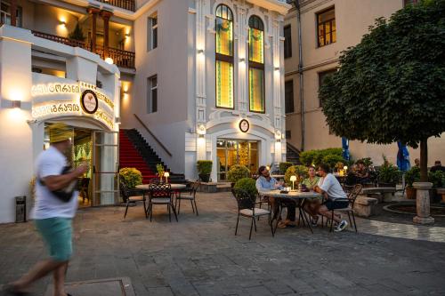 a group of people sitting at tables outside a building at King Gorgasali in Tbilisi City