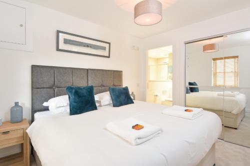 a bedroom with a large white bed with blue pillows at Westview in St. Andrews