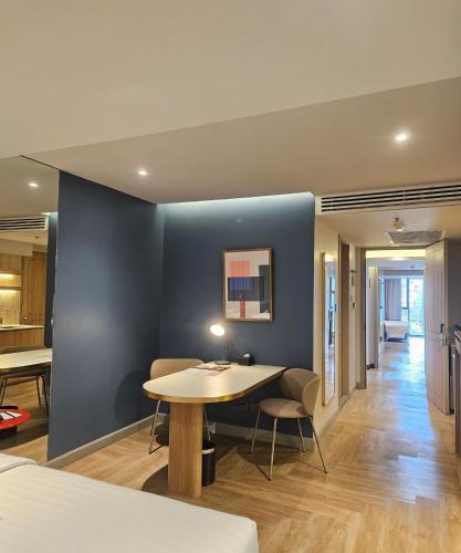 a room with a table and a blue wall at The Quarter Ladprao by UHG in Bangkok