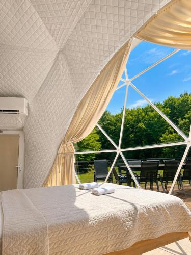 a bedroom with a bed and a large window at Kupolica glamping dome in Brčko