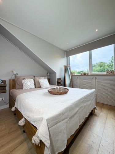 a bedroom with a large bed and a large window at Zilt en Zen Zeeland in Bruinisse