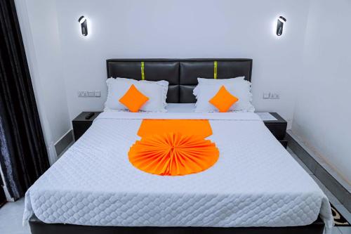 a bed with an orange umbrella on it at Martin Aviator Apartment in Kigali