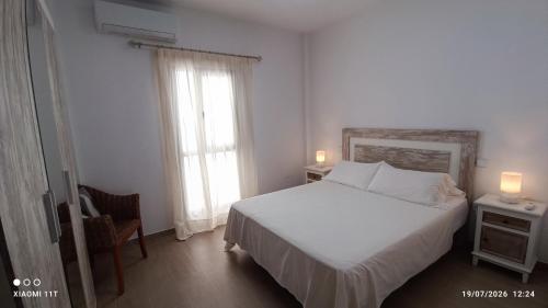 a bedroom with a white bed and a window at Brisa Mar in Gran Tarajal