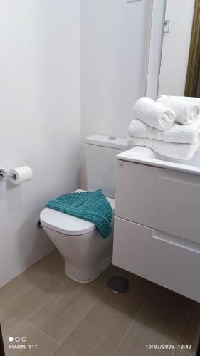 a bathroom with a toilet and a sink and towels at Brisa Mar in Gran Tarajal