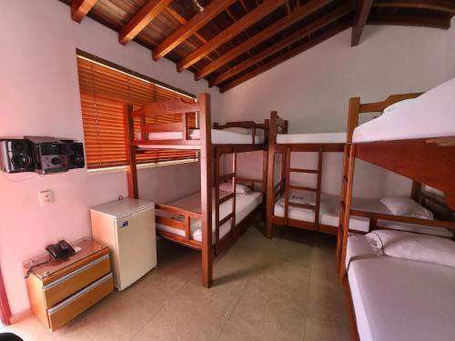 a room with three bunk beds and a window at Hotel Monarca in Medellín