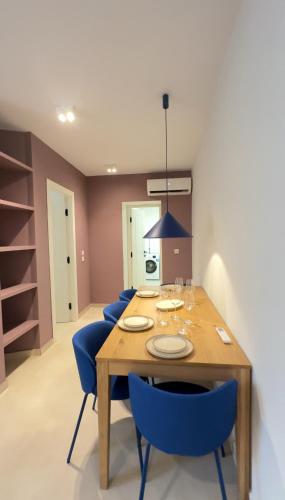a dining room with a wooden table and blue chairs at Cosy place in Pembroke in Pembroke