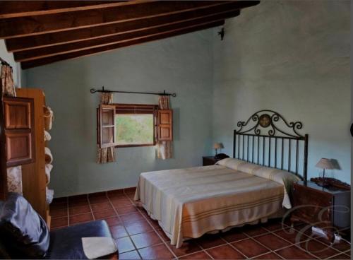 a bedroom with a bed and a window at Casa Rural La Saucedilla in Archidona