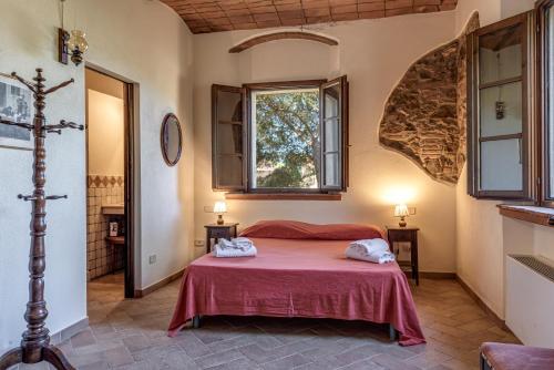 a bedroom with a red bed in a room at Agriturismo Lupo Vecchio in Grosseto