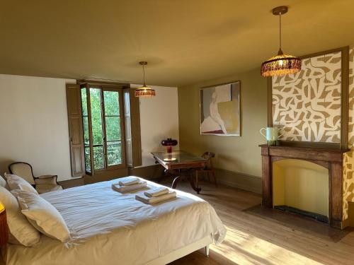a bedroom with a bed and a fireplace and two lights at La Maison du 19 in Cluny
