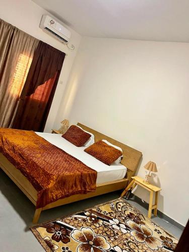 a bedroom with a bed and a rug at L'évasion-Royale in Thiès