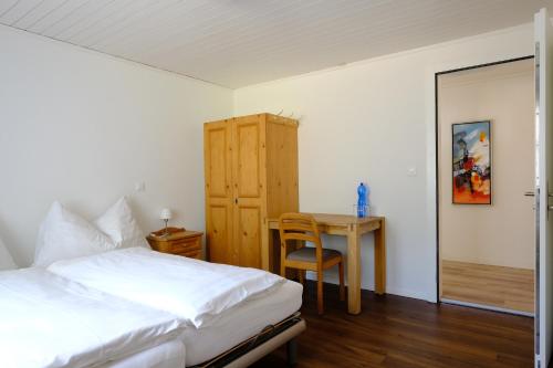 a bedroom with a bed and a desk and a table at Hotel Frieden in Davos