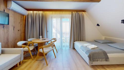 a bedroom with a bed and a table and chairs at Willa Magiera - widok na Trzy Korony in Sromowce Niżne