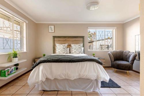 a bedroom with a large bed and a chair at Hephzibah Manor in Alberton