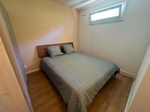 a small bedroom with a bed and a window at Appartement 61 in La Ciotat
